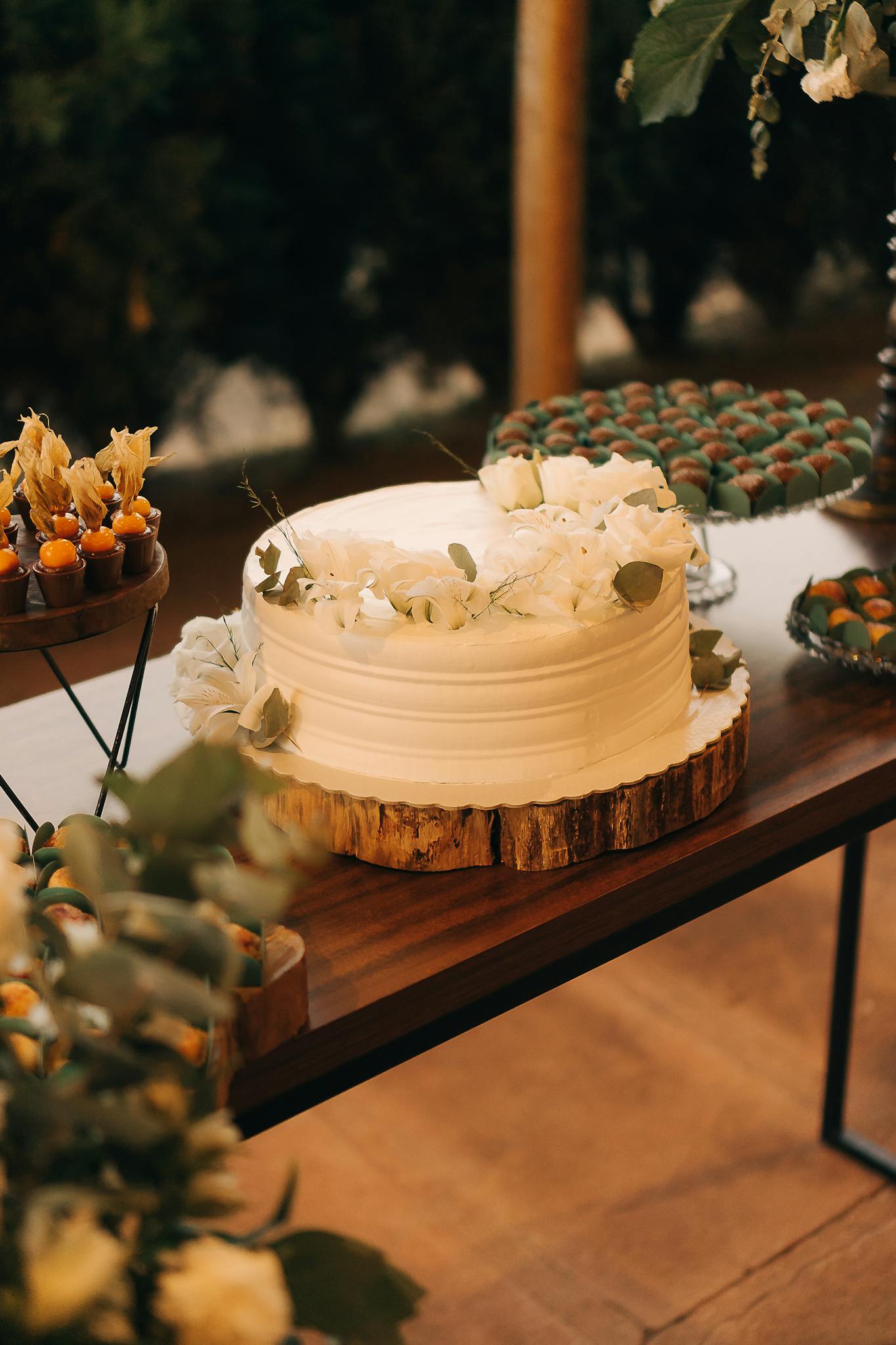 a beautifully decorated white cake displayed on a rustic wooden table for an outdoor celebration. 19870071 1365x2048 1 3minutesfood Catering จากเกษตรอินทรีย์ ร่วมส่งต่อความยั่งยืน
