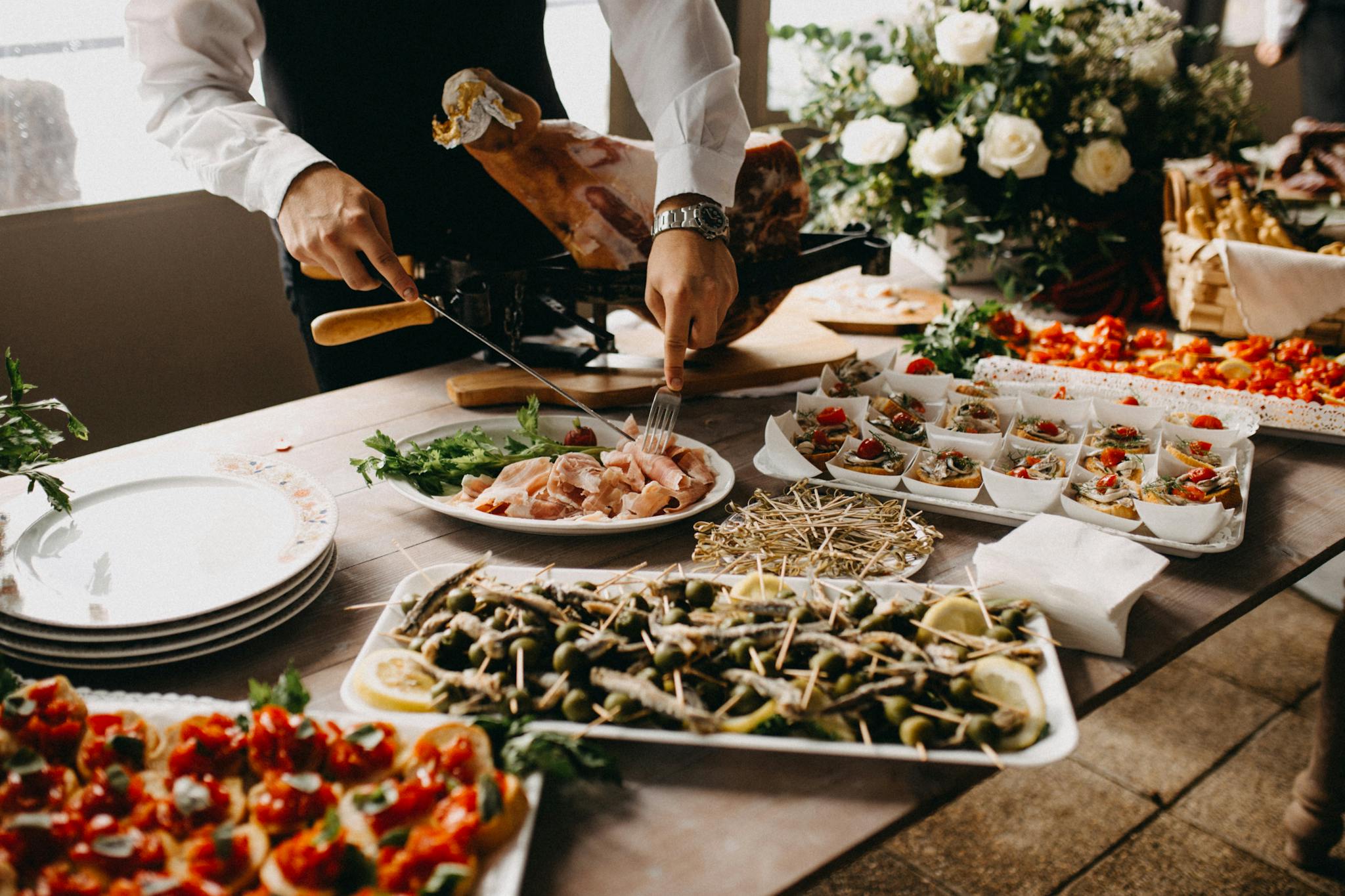 a chef slices meat in a beautifully arranged catering setup with diverse appetizing dishes. 2814828 2048x1365 1 3minutesfood Catering จากเกษตรอินทรีย์ ร่วมส่งต่อความยั่งยืน